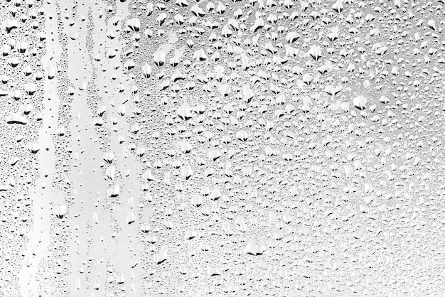 consistenza di una goccia di pioggia su uno sfondo trasparente bagnato di vetro