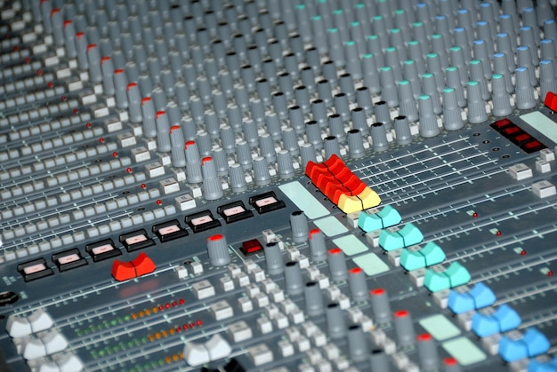 Console di missaggio audio in uno studio di registrazione. Fader e manopole di un mixer audio.