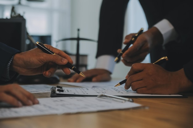 Consultazione e conferenza di avvocati maschi e donne d'affari professionali che lavorano e discutono in uno studio legale in ufficio Concetti di diritto Giudice martello con la bilancia della giustizia