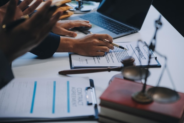 Consultazione e conferenza di avvocati maschi e donne d'affari professioniste che lavorano e discutono in uno studio legale in ufficio Concetti di diritto Giudice martello con la bilancia della giustizia