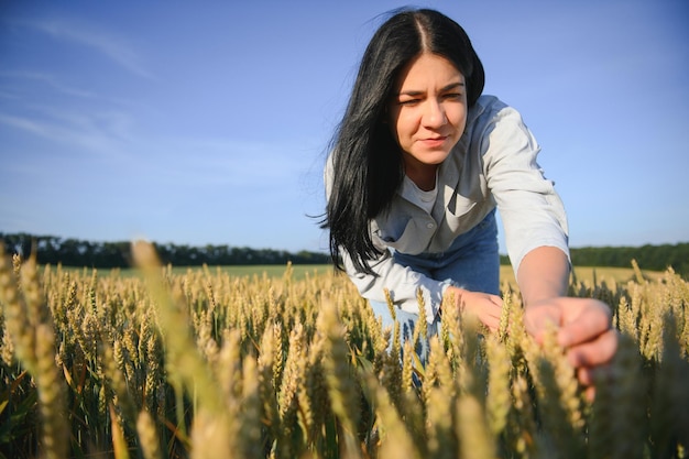 Contadina in un campo di grano al tramonto