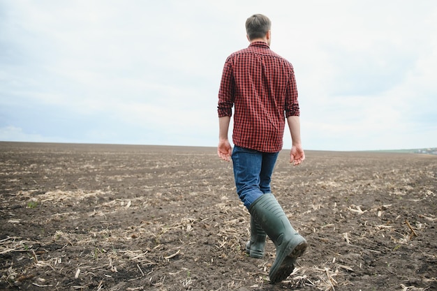 Contadino che cammina tra i campi agricoli