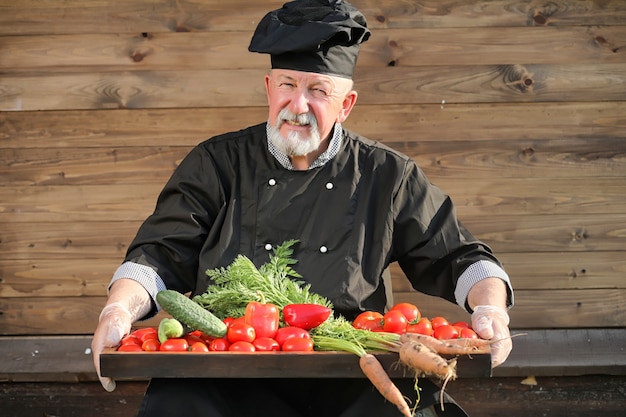 Contadino con un cesto di verdure fresche in campagna