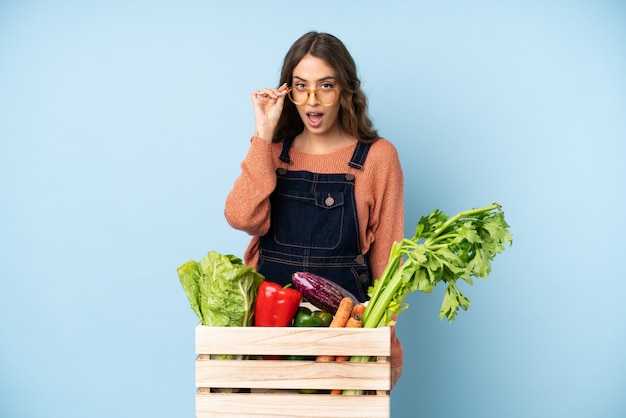 Contadino con verdure appena raccolte in una scatola con gli occhiali e sorpreso