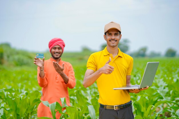 Contadino indiano con banchiere o agronomo al campo agricolo.