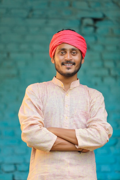Contadino indiano in abiti tradizionali e che dà un'espressione felice a casa
