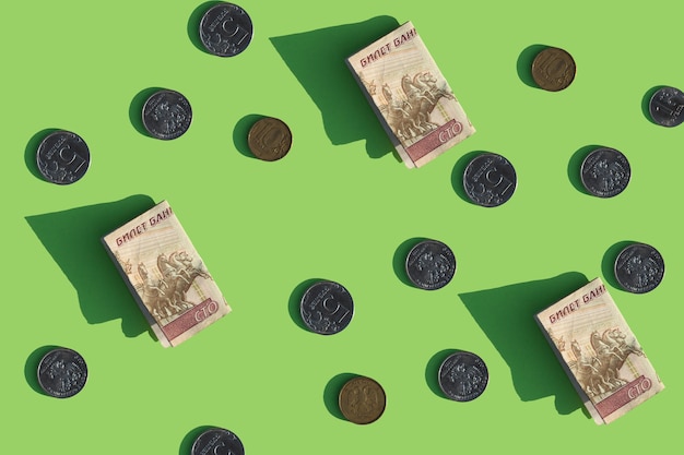 contanti e monete su uno sfondo verde brillante Rubli valuta russa Pattern