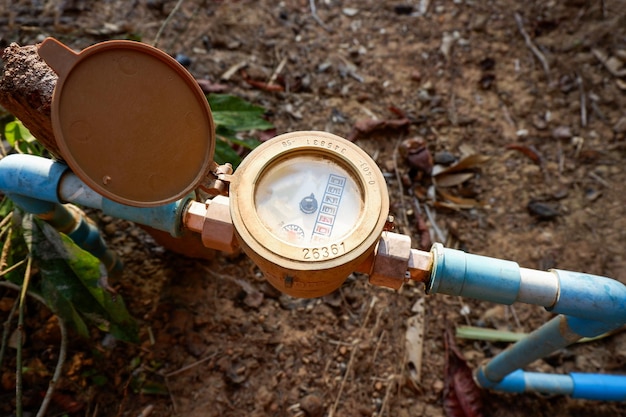 Contatore dell'acqua sul tubo dell'acqua in pvc sul terreno vecchio contatore dell'acqua per controllare le stime sull'utilizzo dell'acqua domestica nel villaggio