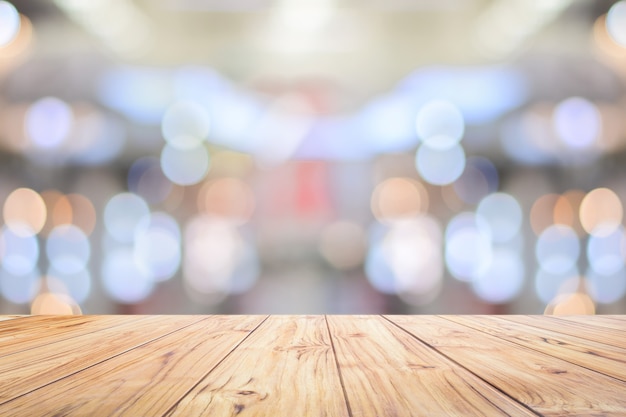 Contatore di legno del piano d'appoggio sul fondo interno del bokeh luminoso con il piano d'appoggio bianco