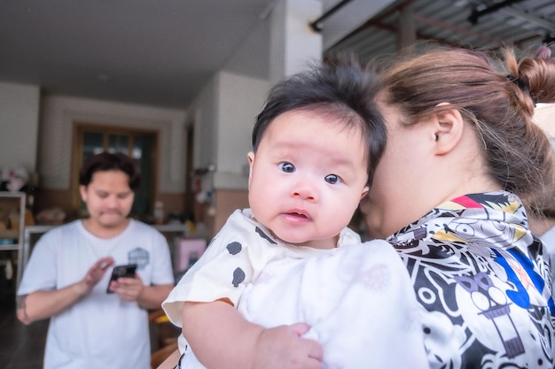 Contatto visivo del bambino del neonato asiatico con la carineria della mamma dei bambini