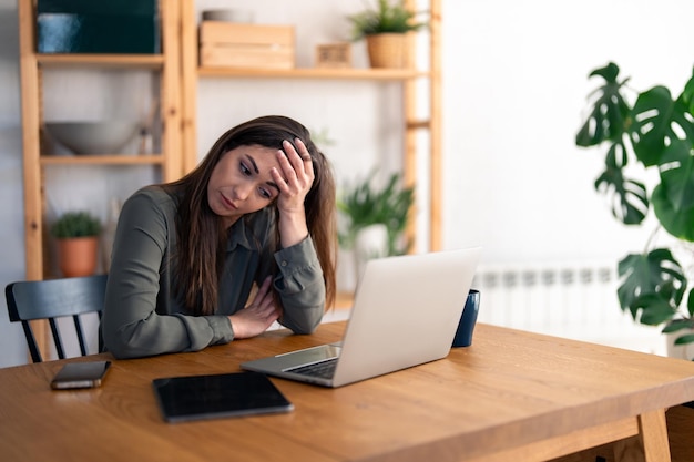 Contemplare una donna d'affari che lavora da casa sentendosi triste Una donna d'azienda professionale seduta in ufficio a casa con un aspetto stanco con dolore sonnolento ed esausto stanchezza