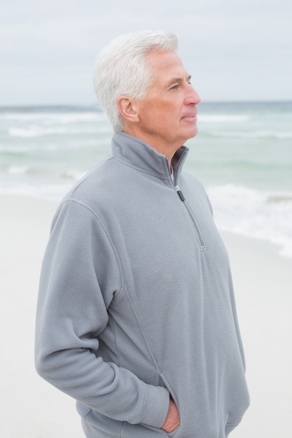 Contemplativo casual uomo anziano in spiaggia