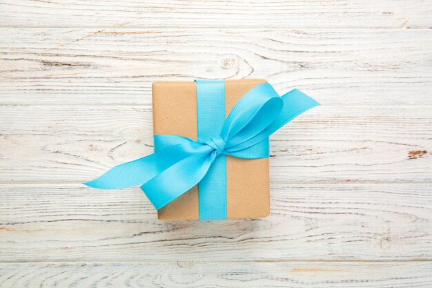Contenitore di regalo di carta riciclata con nastro blu su legno vecchio