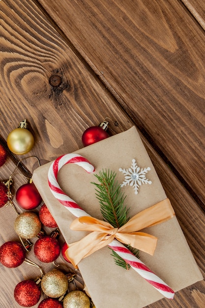 Contenitore di regalo di Natale, decorazione e ramo di albero di abete sulla tavola di legno. Vista dall'alto con copyspace