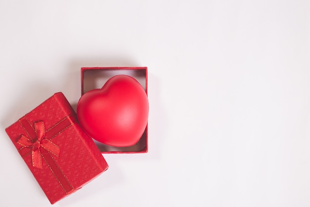 Contenitore di regalo di nozze o di San Valentino sul fondo del Libro Bianco con cuore rosso