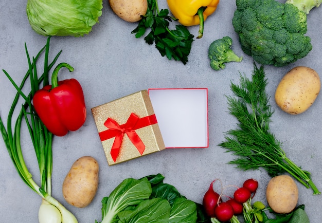 Contenitore di regalo e verdure su una tabella.