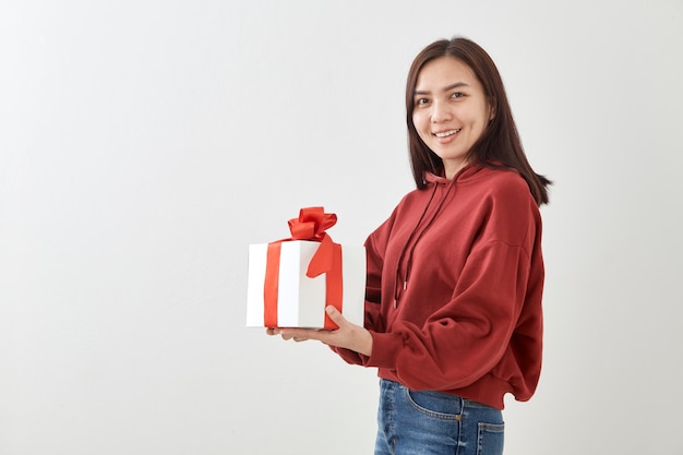 Contenitore di regalo felice della tenuta della giovane donna in mani