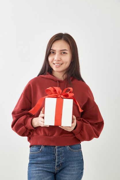 Contenitore di regalo felice della tenuta della giovane donna in mani