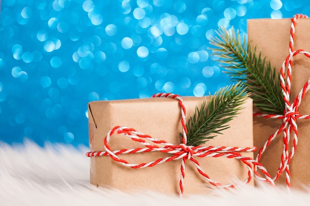 Contenitore di regalo kraft di Natale sulla superficie scintillante blu