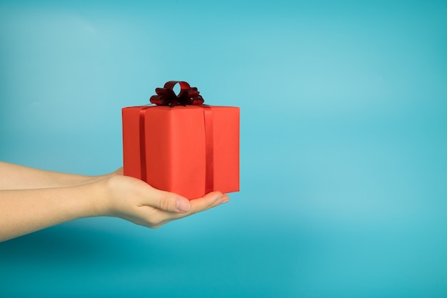 Contenitore di regalo rosso a disposizione con priorità bassa blu-chiaro