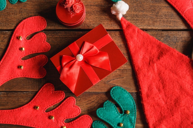 Contenitore di regalo rosso e cappello della santa su fondo di legno