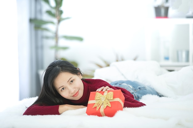 Contenitore di regalo rosso sorridente della tenuta asiatica della donna