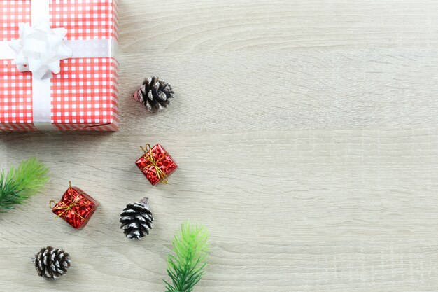 Contenitore di regalo rosso sulla priorità bassa di legno del pavimento.