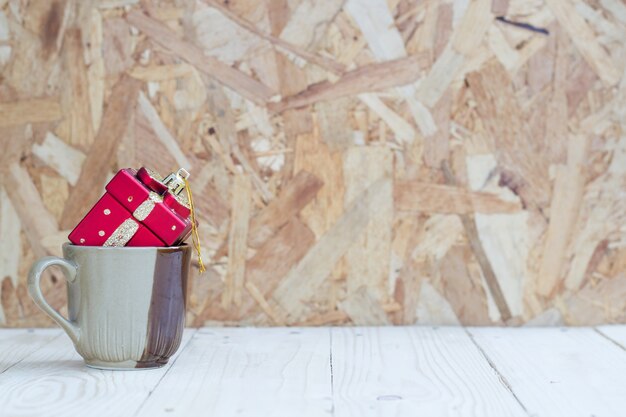 Contenitore di regalo sulla tazza con fondo di legno