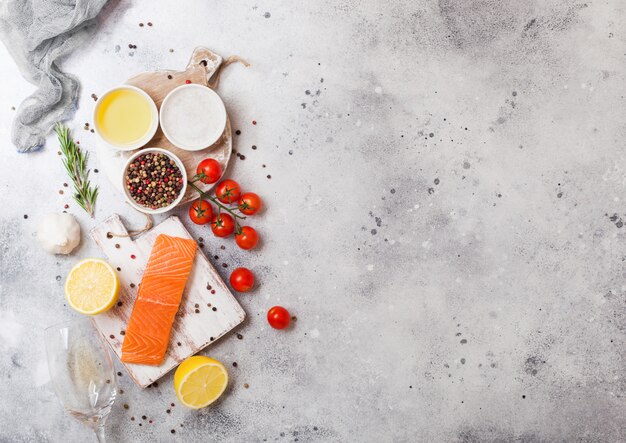 Contenitore in plastica con fetta di salmone fresco con olio, pomodori e limone