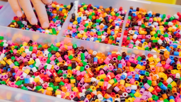 Contenitore in plastica con perline colorate per bambini.