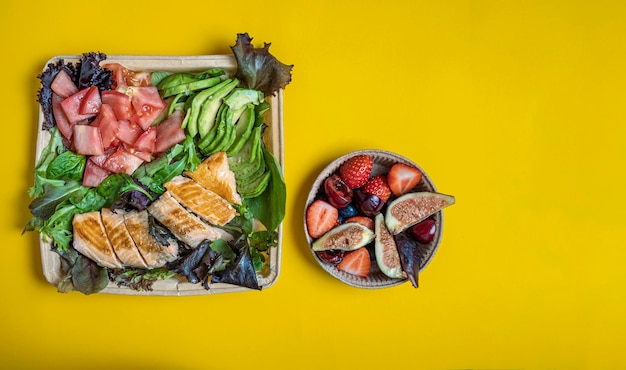 Contenitore per alimenti con cibo sano per andare su sfondo giallo Vista dall'alto