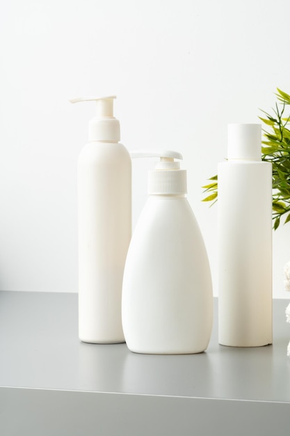 Contenitori cosmetici in plastica bianchi in un bagno da vicino