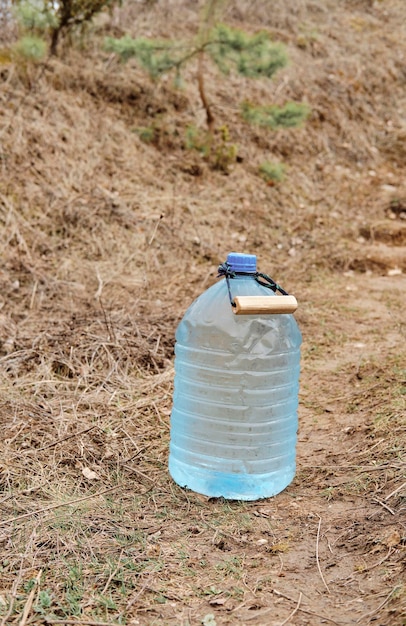 Contenitori da cinque litri con acqua potabile chiara e pulita sul lato della strada vicino alle scale