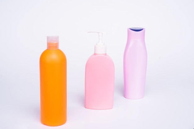Contenitori da toilette in plastica per prodotti cosmetici liquidi in fila isolati su bottiglie bianche
