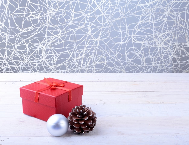 Contenitori di regalo con le palle di natale e dell'arco su fondo di legno