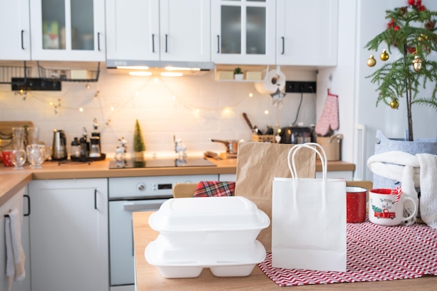 Contenitori per il servizio di consegna di cibo sul tavolo bianco scandi cucina festiva in decorazioni natalizie vigilia capodanno risparmiando tempo troppo pigro per cucinare ordine caldo scatola di plastica usa e getta in fata mock up