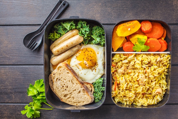 Contenitori per preparare il pasto con riso con pollo, verdure al forno, uova, salsicce e insalata.