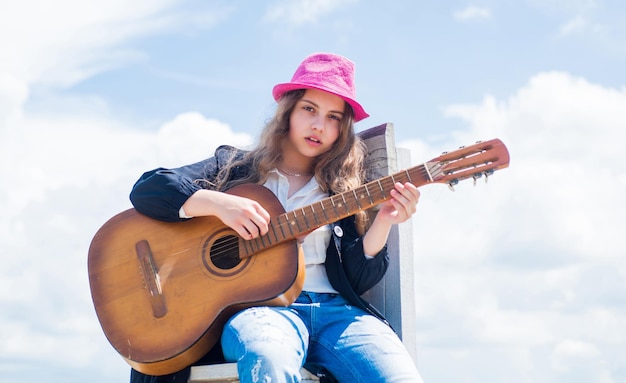 Contenuti musicali gratuiti Musicista adolescente che suona la chitarra Ritratto di bambino che suona la chitarra sullo sfondo del cielo playlist romantica estiva Chitarrista che intrattiene gli ospiti alla festa piccolo amante della musica