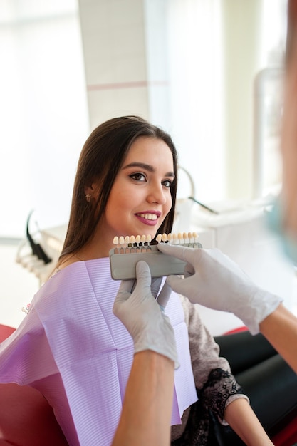 Controlla e seleziona il colore dei denti per la bella ragazza bruna