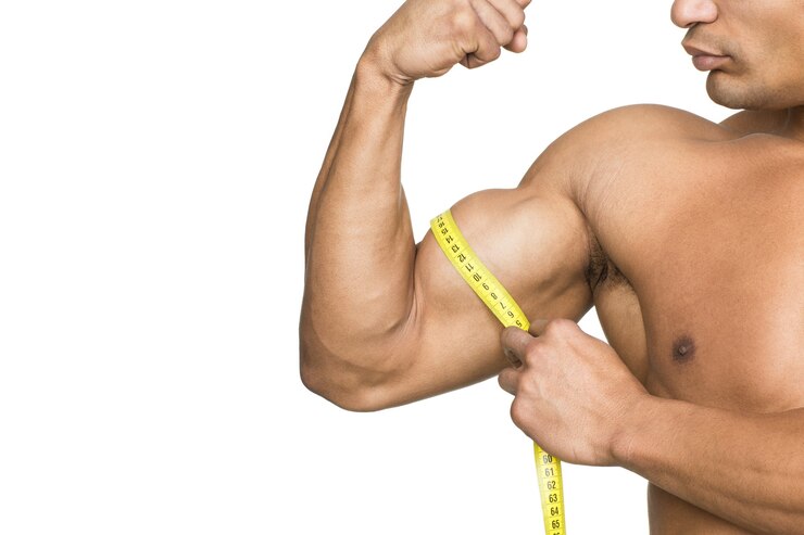 Controlla quei muscoli! Ritagliata colpo di un bodybuilder strappato che misura i suoi bicipiti isolati su bianco