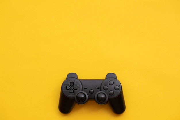 Controller per videogiochi nero su sfondo giallo brillante