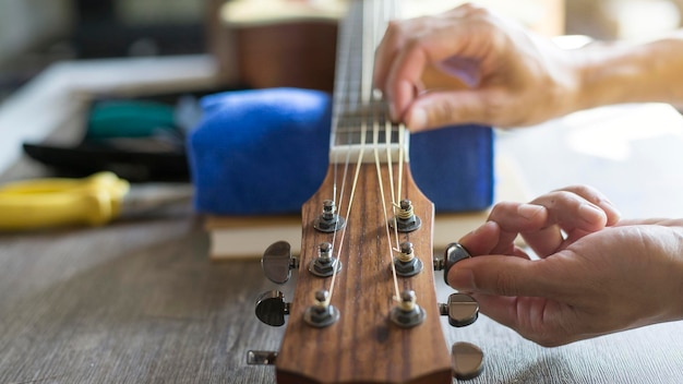 Controllo della corda della chitarra acustica Expert sta accordando la corda della chitarra Closeup