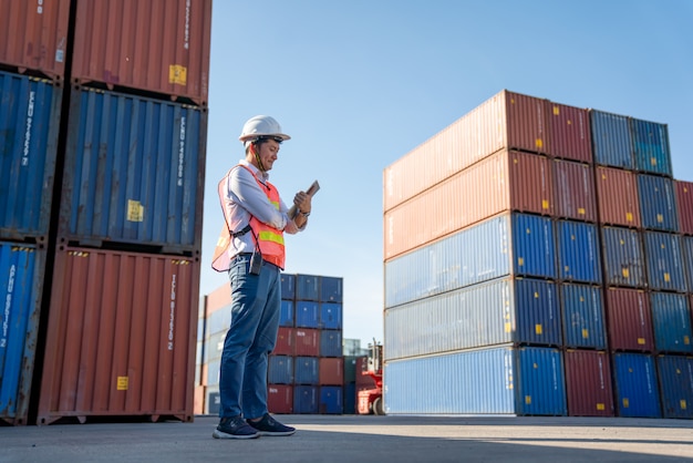 Controllo ingegnere logistico nel porto, caricamento container per esportazione camion e importazione logistica