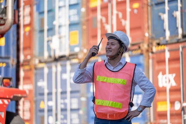 Controllo ingegnere logistico nel porto, caricamento container per esportazione camion e importazione logistica