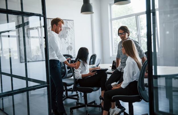 Conversazione attiva. Giovani uomini d'affari in abiti formali che lavorano in ufficio.