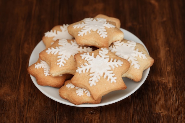 Coockies saporiti di natale decorati con zucchero sul piatto, primo piano