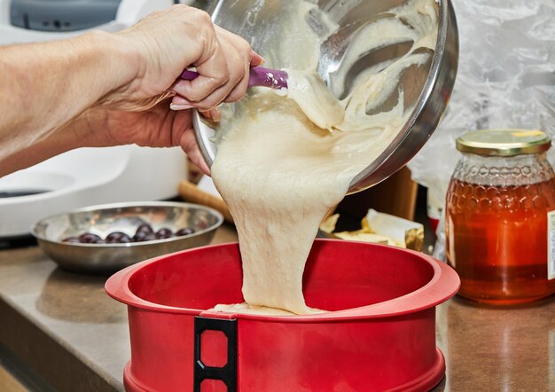 Cook mette l'impasto in una tortiera di silicone.