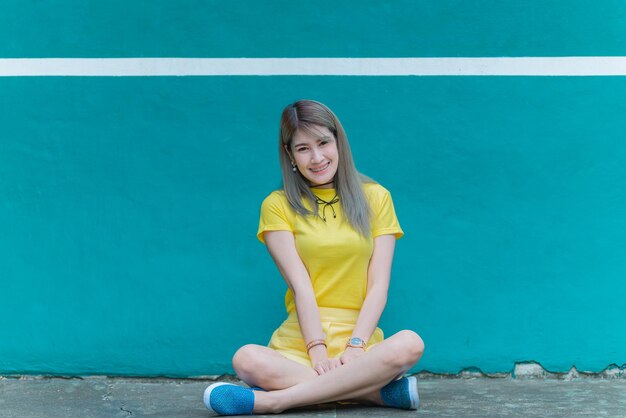 Cool Asian hipsters girl indossare un abito giallo in posa per scattare una fotolifestyle di donna modernaPopolo tailandese in stile hippieGiornata fredda per rilassarsi