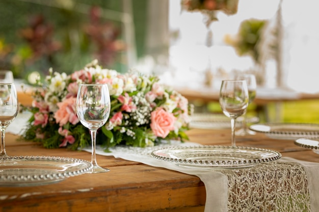 Copa de cristal sobre una mesa con arreglos florales