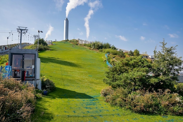 Copenhagen, Danimarca. 10 agosto 2021. Piste da sci verdi con scivoli e kicker in cima all'Amager Bakke, impianto di termovalorizzazione di Copenhill a Copenhagen, Danimarca